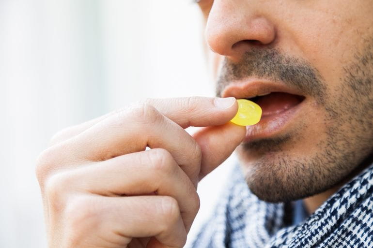 Strepsilst evő férfi